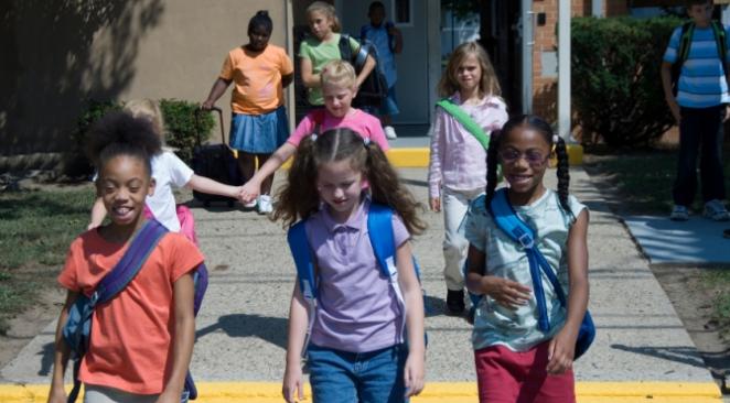 Children walking out of school building.