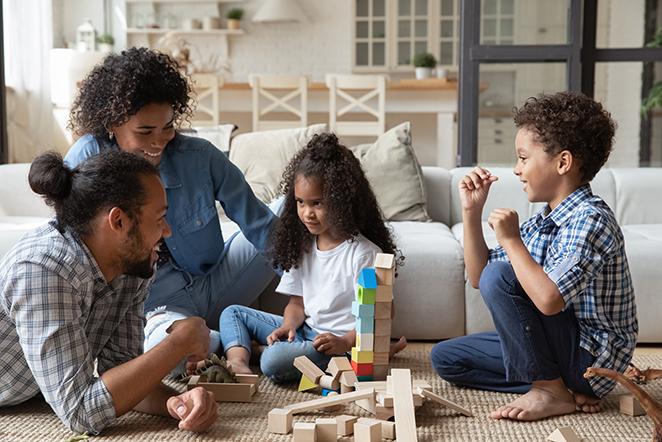 Black family playing with wooden blocks.