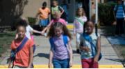 Children walking out of school building.