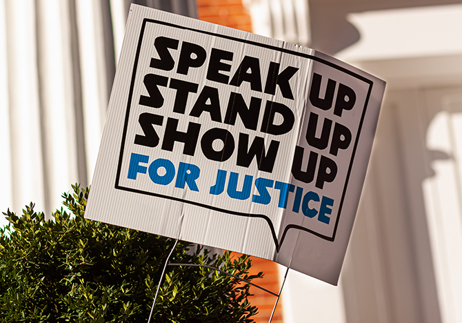 Yard Sign saying Speak up, stand up, show up for justice.